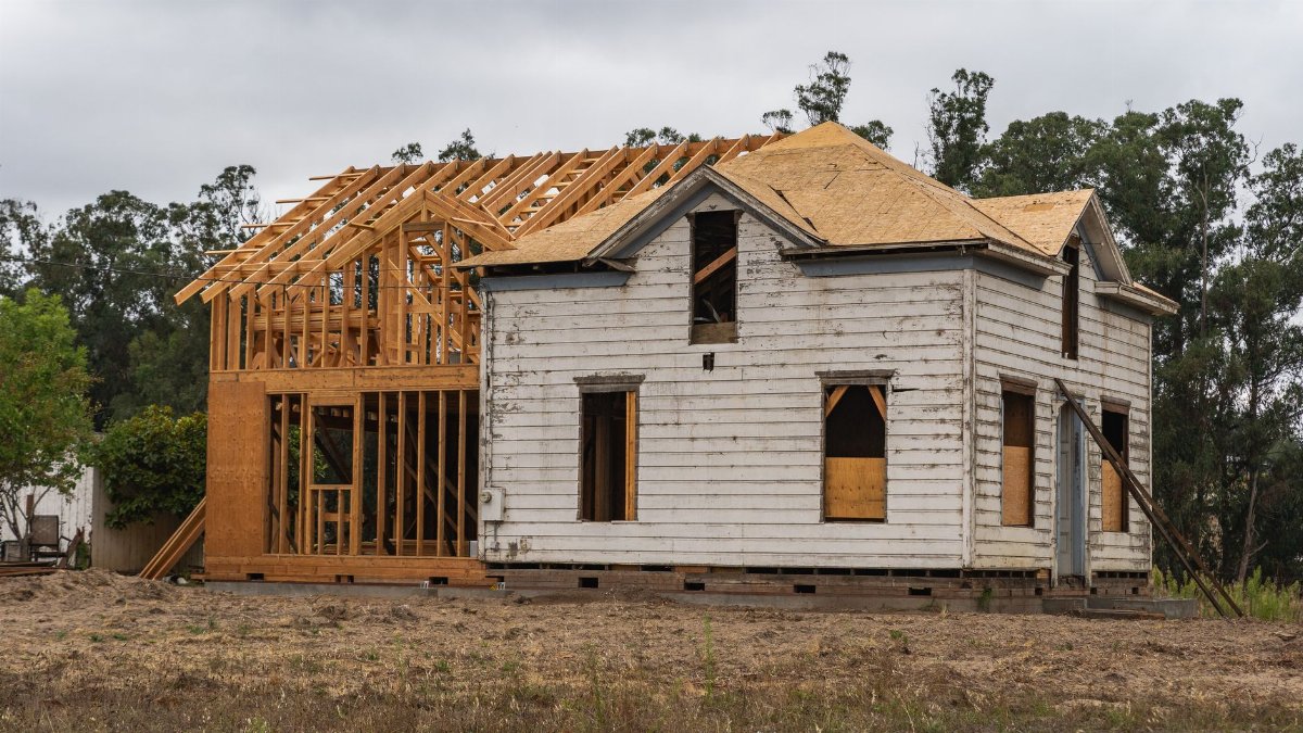 Image of an old house under renovation with new wooden frame structure.