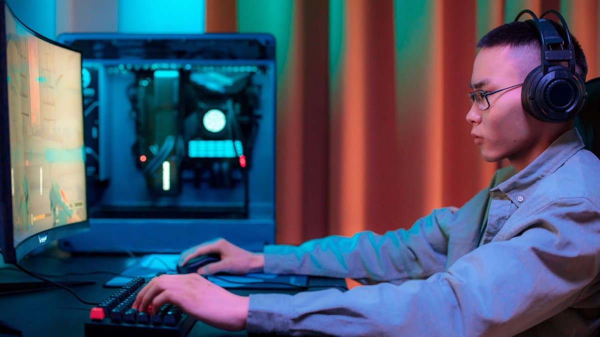 Intense gaming session of an adult male with headphones in a modern setup.