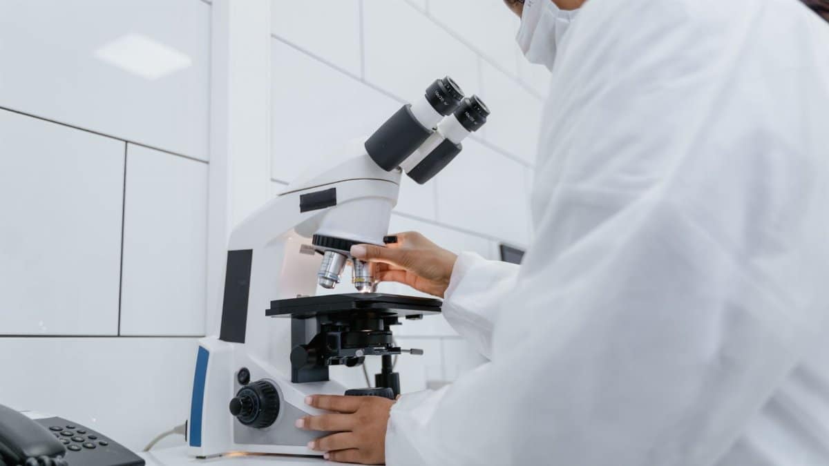 Scientist using microscope for research in a modern laboratory setting.