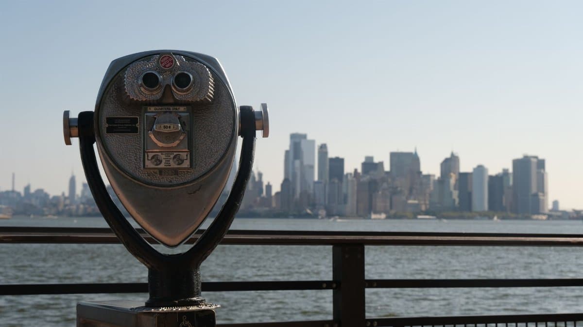Coin-operated binoculars with a view of the New York City skyline across the water.