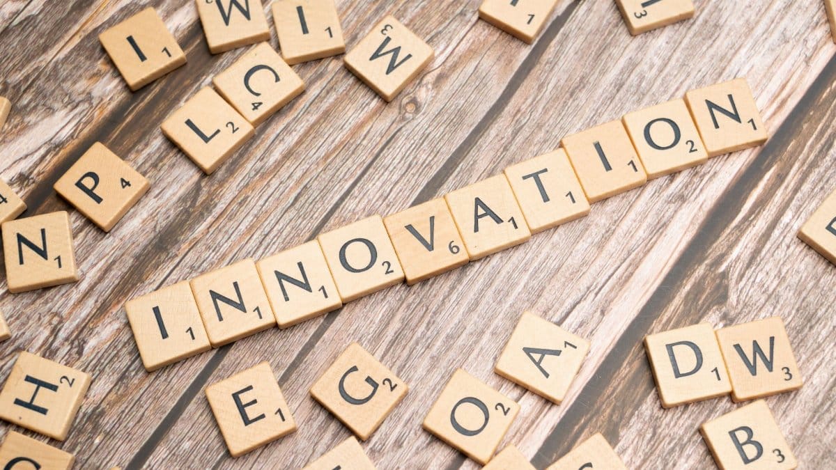 Creative display of 'Innovation' spelled with wooden letter tiles on a wooden surface.
