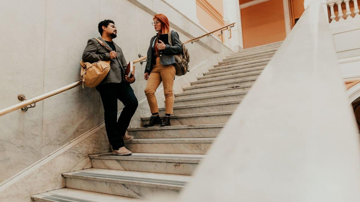 Two students engaged in conversation on a marble staircase at a university in Buenos Aires, Argentina.
