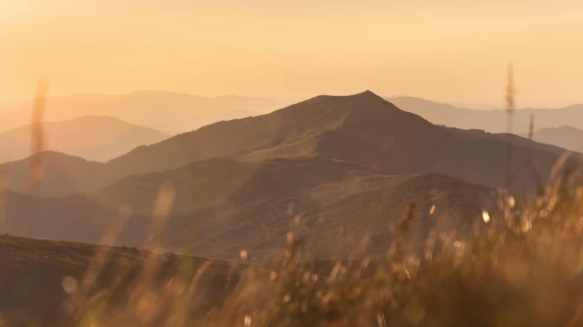 Captivating view of a mountain range in golden sunlight, ideal for nature and travel themes.