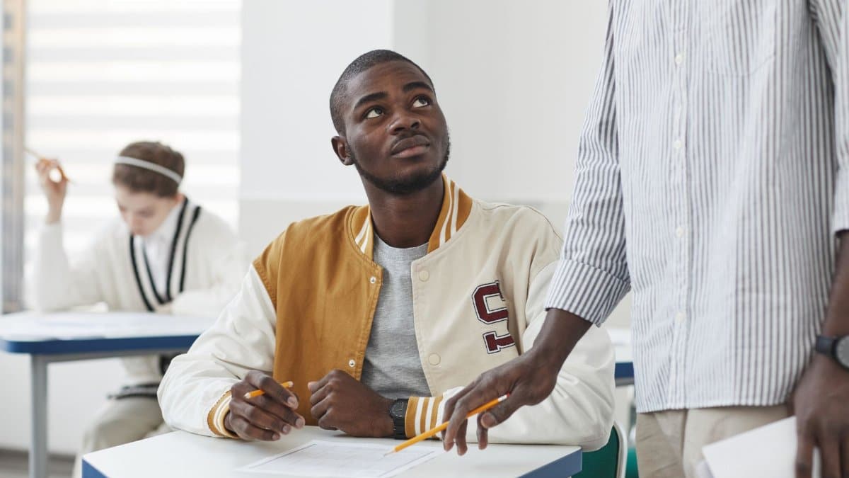 Attentive student in a classroom setting looking at teacher during lesson.
