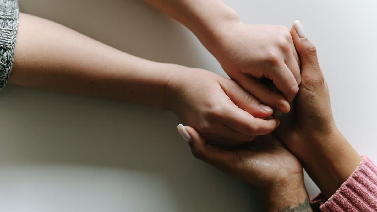 Close-up of diverse hands holding, symbolizing care, support, and friendship.