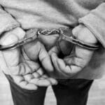 Rear view of a man in handcuffs, captured in monochrome.