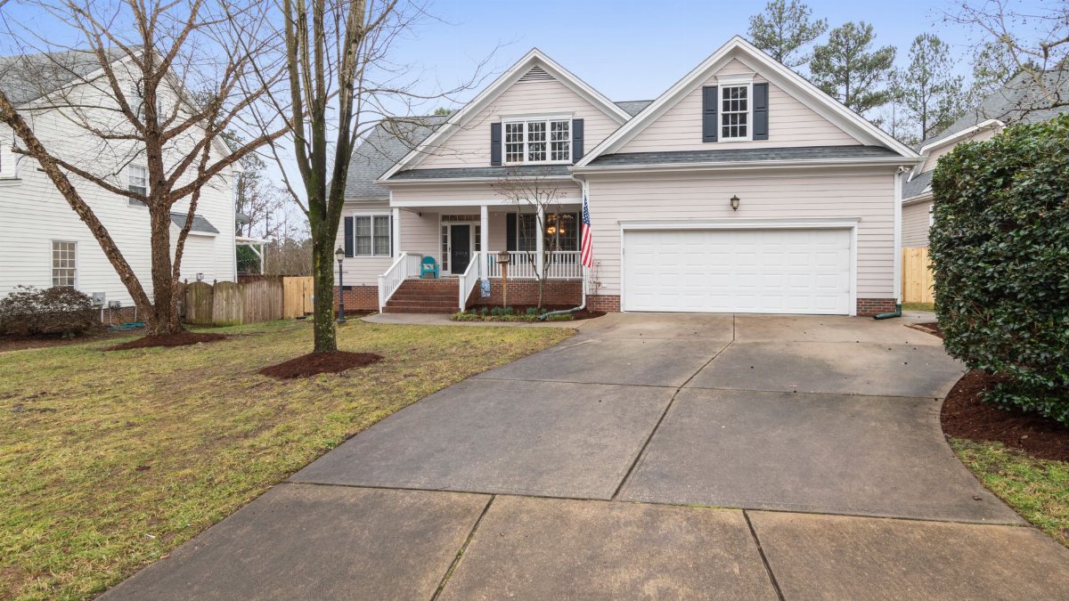 A well-maintained suburban house exterior with a large driveway, perfect for real estate listings.
