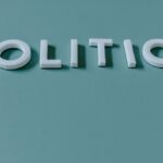 Close-up image of the word 'Politics' against a teal green background, highlighting political themes.