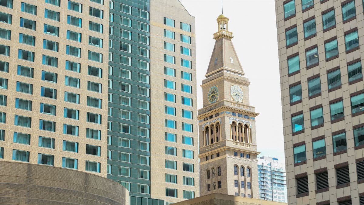 Iconic Daniels & Fisher Tower flanked by modern skyscrapers in Denver's cityscape.