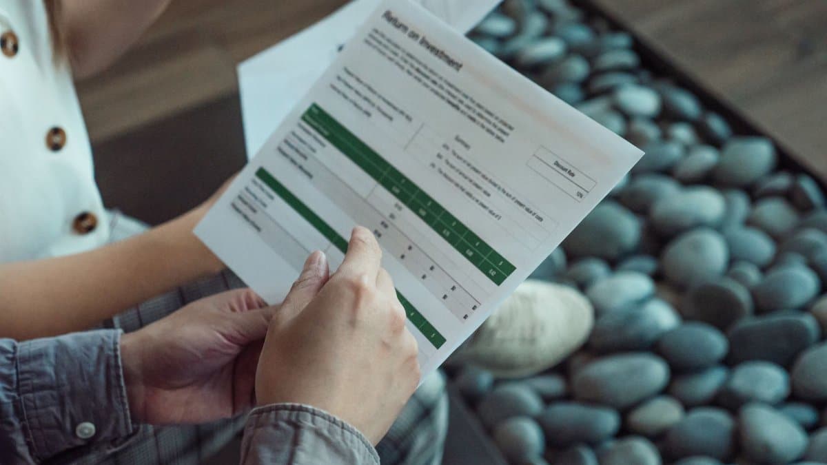 Two people discussing a financial document showing return on investment data.
