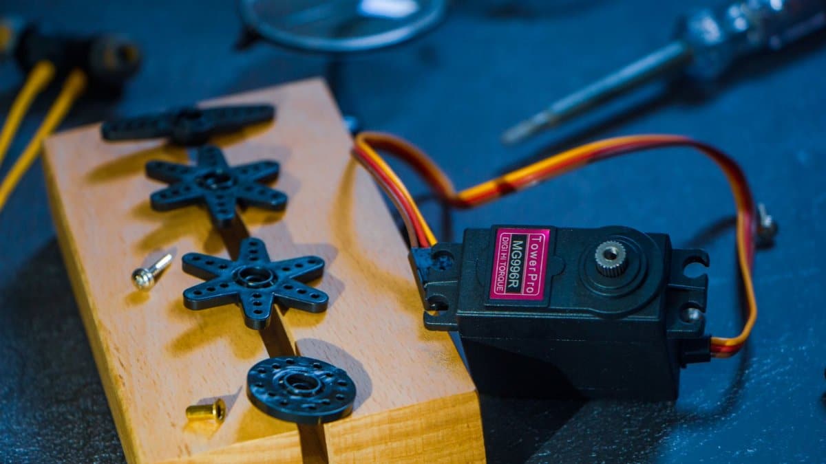 A servo motor and gear set on a wooden block, perfect for robotics enthusiasts and engineers.