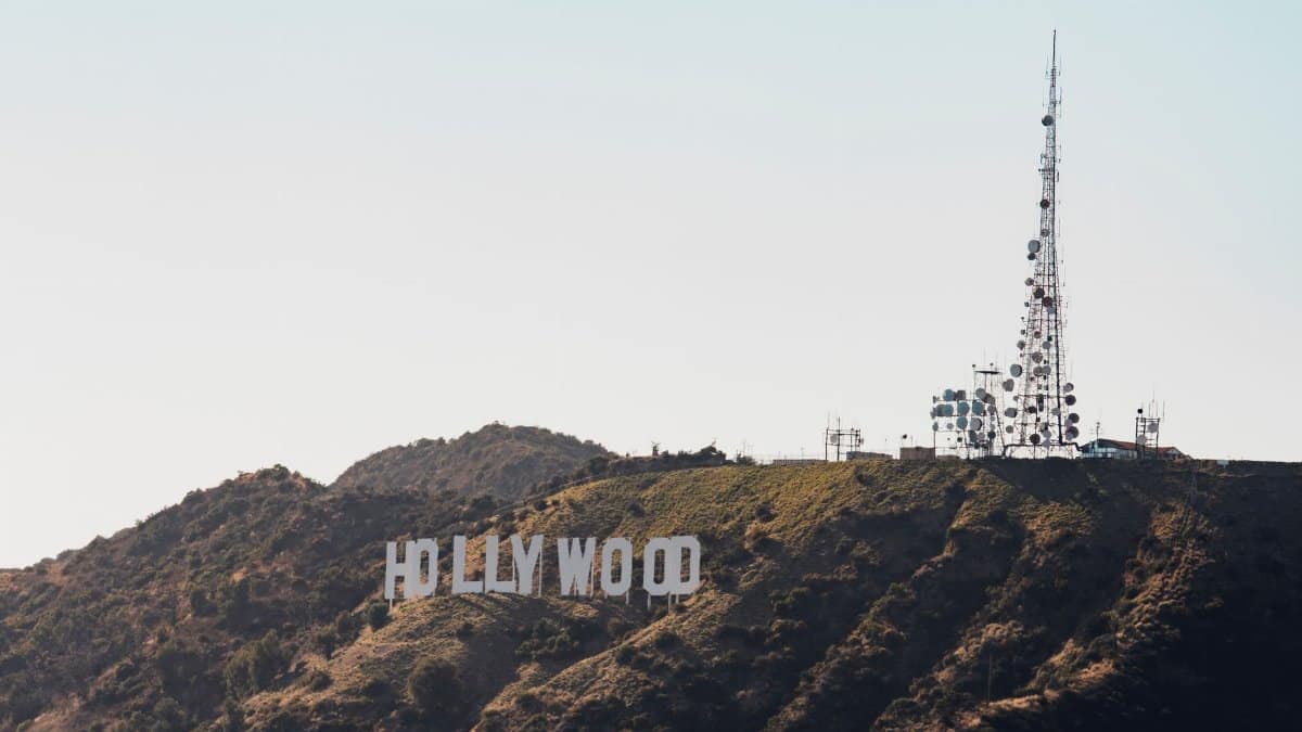 The famous Hollywood Sign and radio tower on a sunny day in Los Angeles.