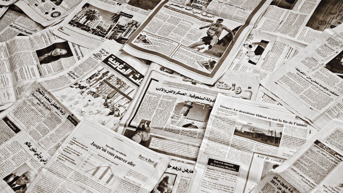 A collection of Arabic newspapers spread across a surface, showcasing diverse headlines and articles.