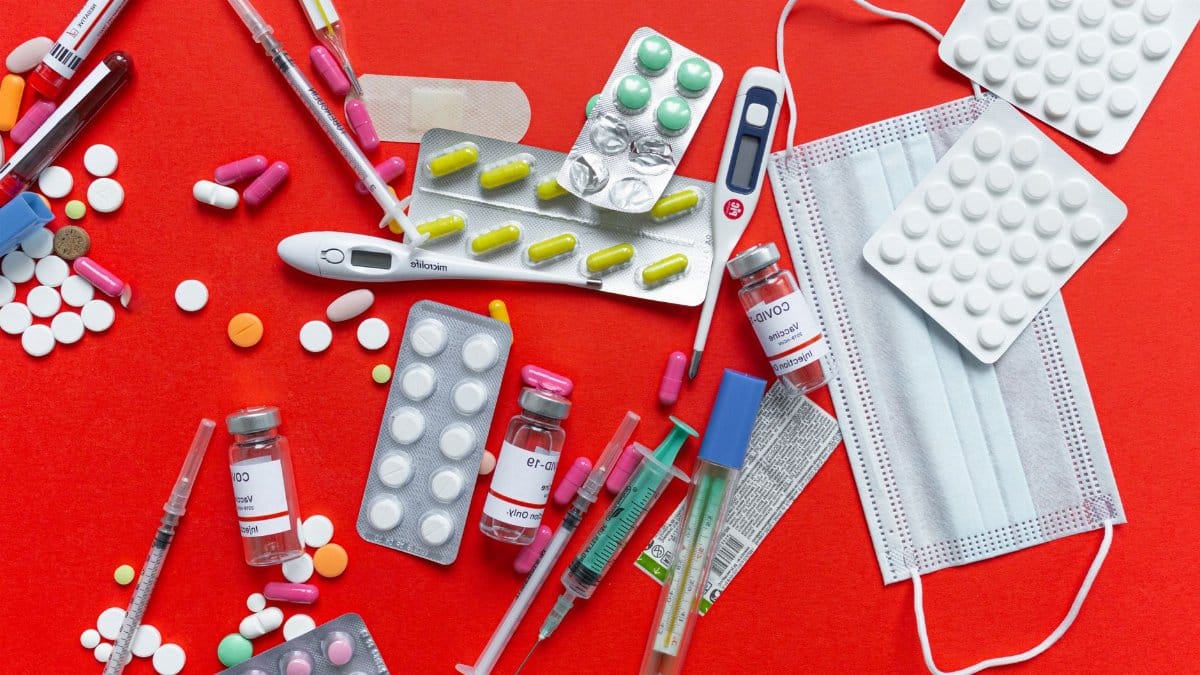 Medical supplies and medications displayed on a red background, emphasizing healthcare essentials.
