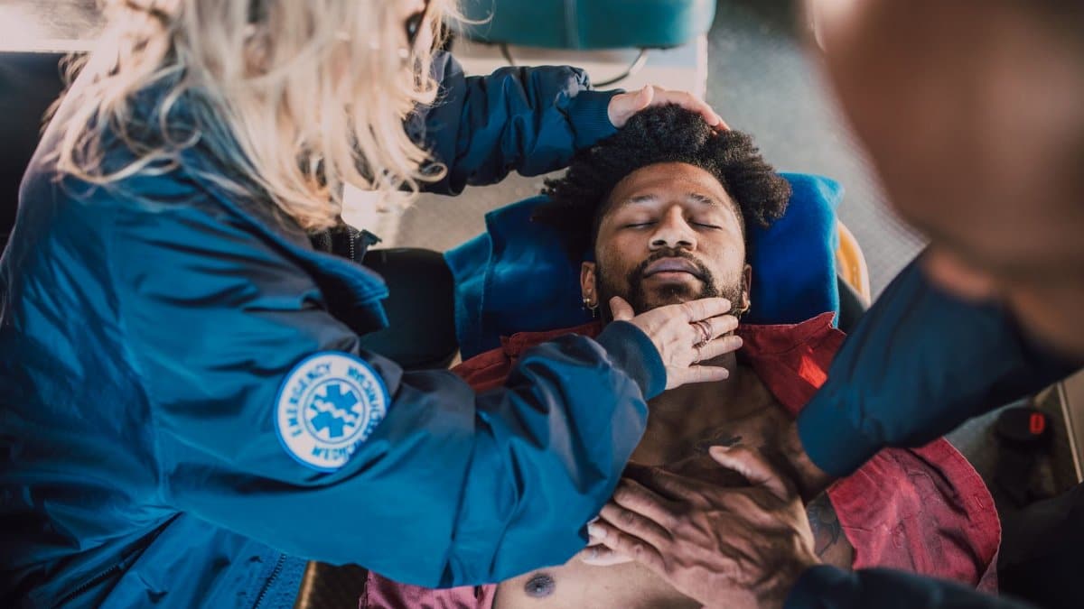 Paramedics administer life-saving CPR to unconscious patient during emergency response.
