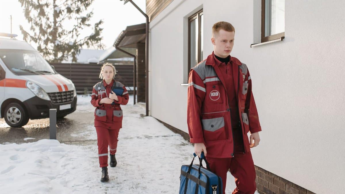 Medical professionals arriving at a snowy scene with emergency equipment.
