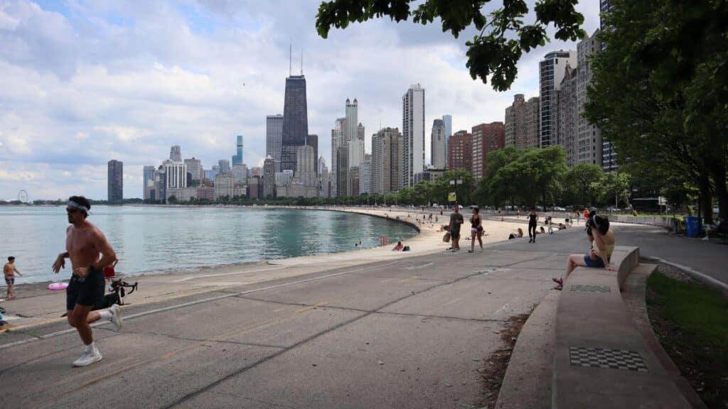 Scenic view of Chicago skyline from Lake Michigan trail with runners and cityscape view.