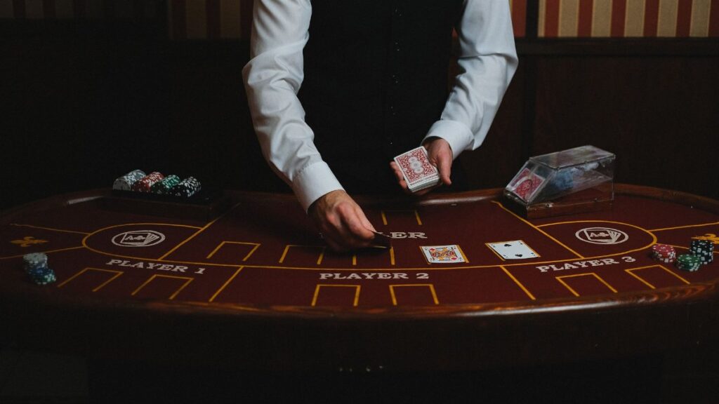 A casino dealer handling cards at a gaming table, ready for blackjack or poker.