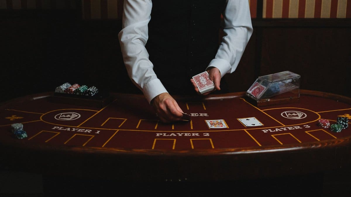 A casino dealer handling cards at a gaming table, ready for blackjack or poker.