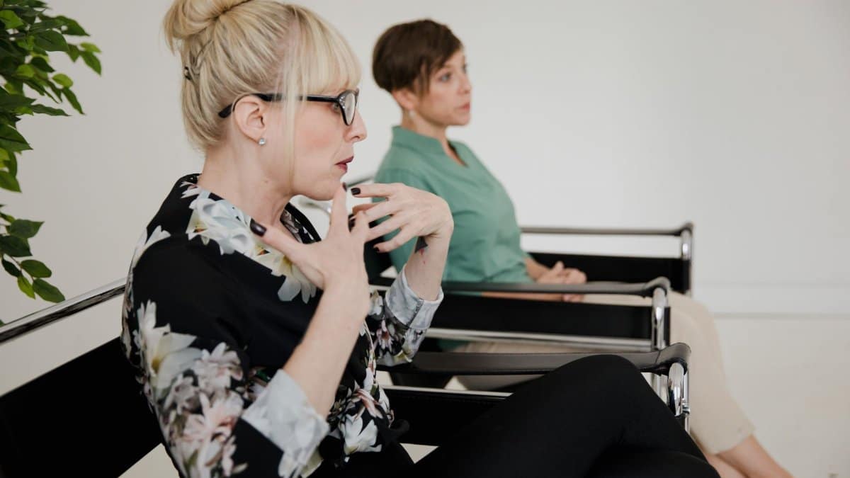 A therapist and client interact during a mental health session indoors.
