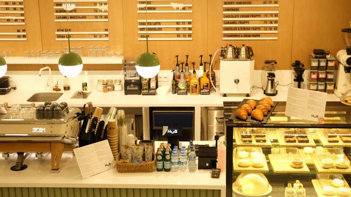 Warm coffee shop interior with menu boards, croissants, and dessert display. Ideal for food and beverage themes.