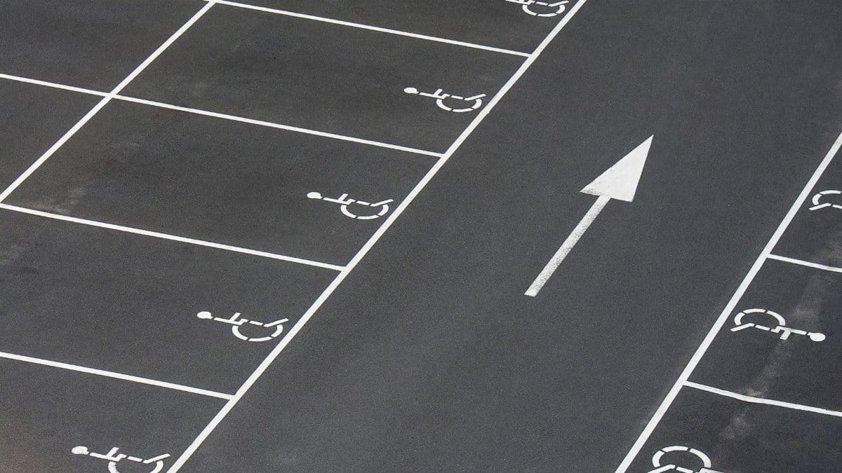 A clean parking lot featuring multiple handicapped spaces and a directional arrow marking.