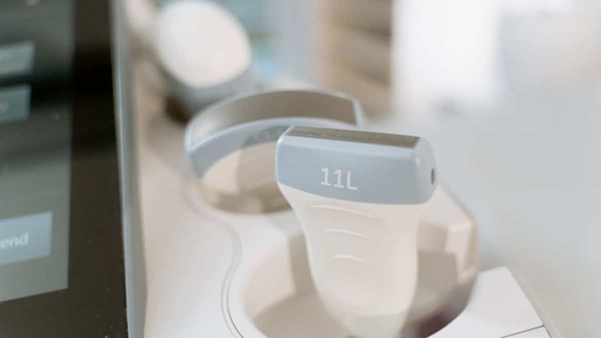 Detail shot of an ultrasound scanner probe in a medical facility setting.