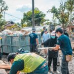 Volunteers work together to clean up debris after a natural disaster, showcasing community effort and teamwork.