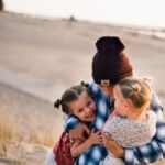 A loving family moment captured on a sunny day at a beach in Holland, MI.