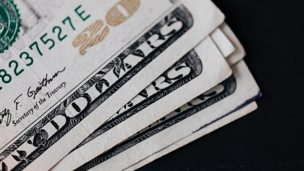 Closeup of USA 20 dollar banknotes placed on black background as national currency for business and personal financial operations