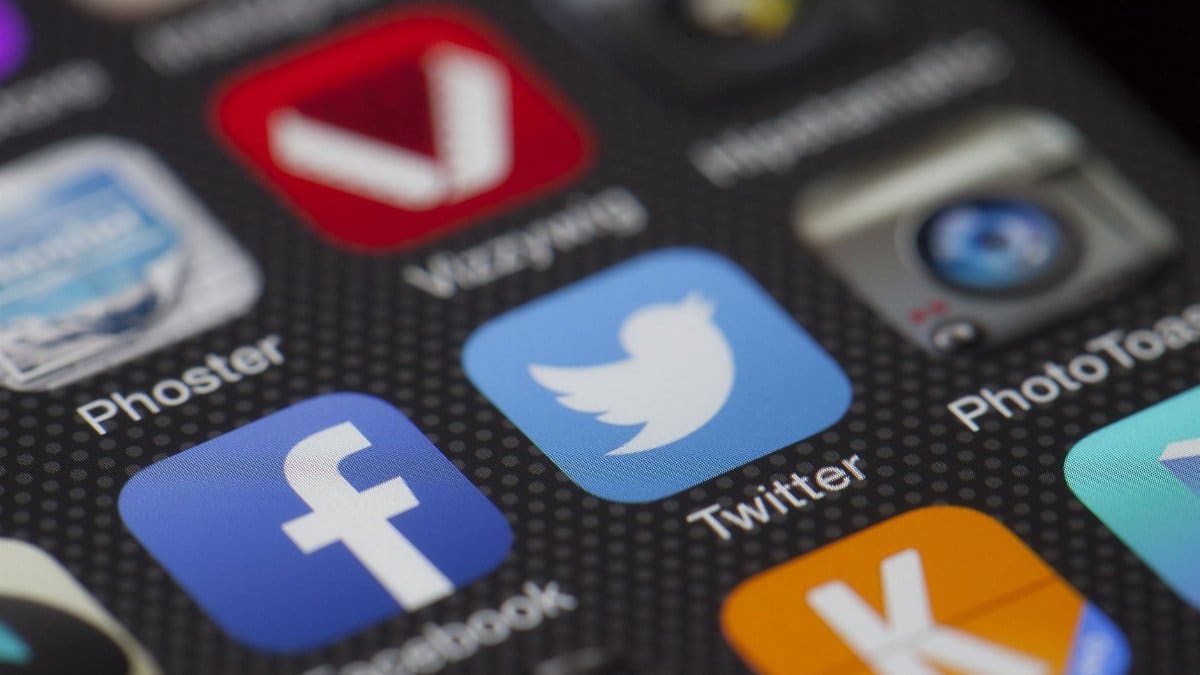 A detailed close-up of social media icons on a smartphone screen, including Facebook and Twitter.