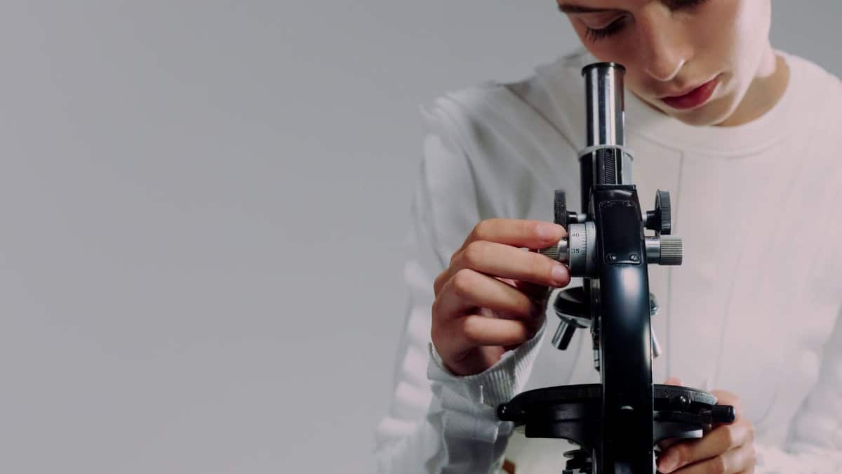 A scientist carefully examining samples using a microscope in a modern laboratory setting.