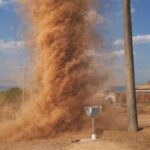 Impressive dust devil swirling on an open road in Tocantins, Brazil under a clear blue sky.