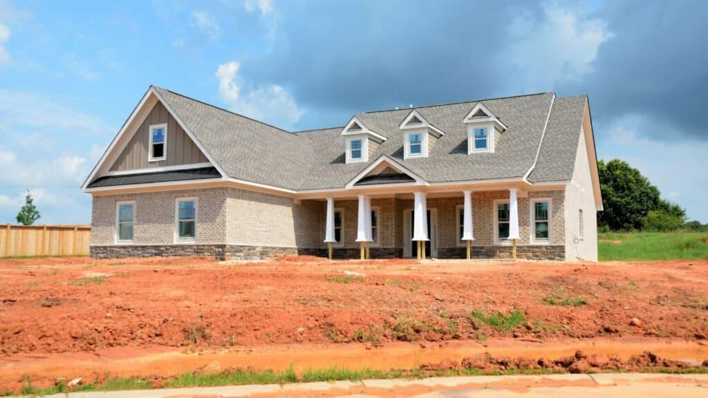 Brick modern family home under bright sky, showcasing new construction and architectural style.
