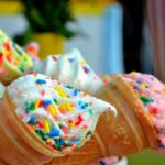 Vibrant ice cream cones topped with colorful sprinkles, perfect for summer treats.