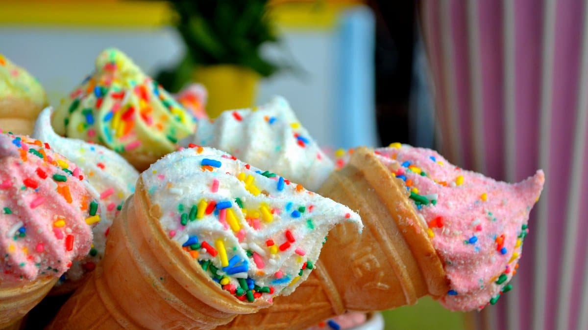 Vibrant ice cream cones topped with colorful sprinkles, perfect for summer treats.