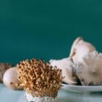 Small brown nameko mushrooms placed on white table of kitchen on green background