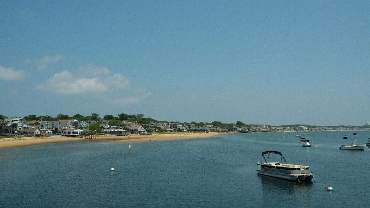 Scenic view of Nantucket coast with moored boats under a clear summer sky.