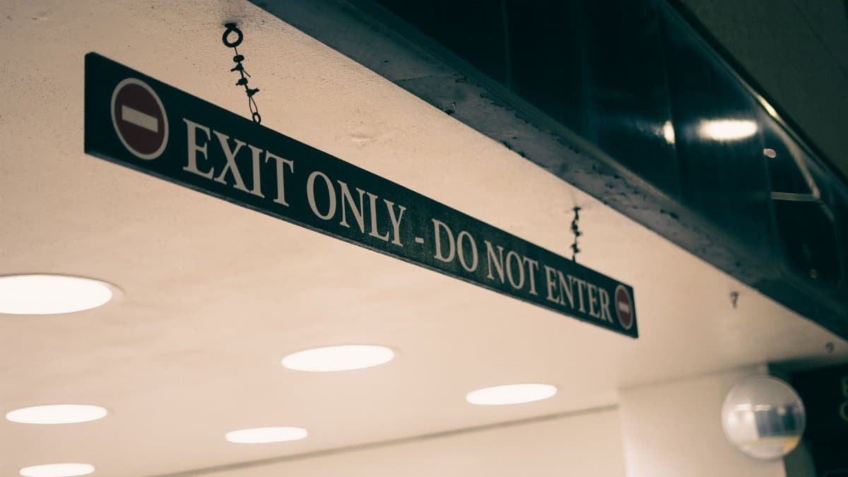 Close-up of an 'Exit Only' and 'Do Not Enter' sign in an indoor urban setting.