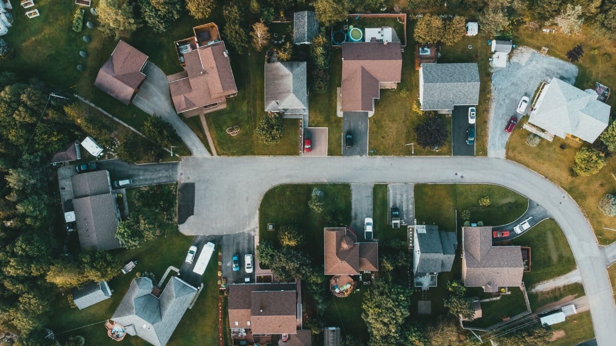A top-down view of a suburban neighborhood showing houses, streets, and greenery.