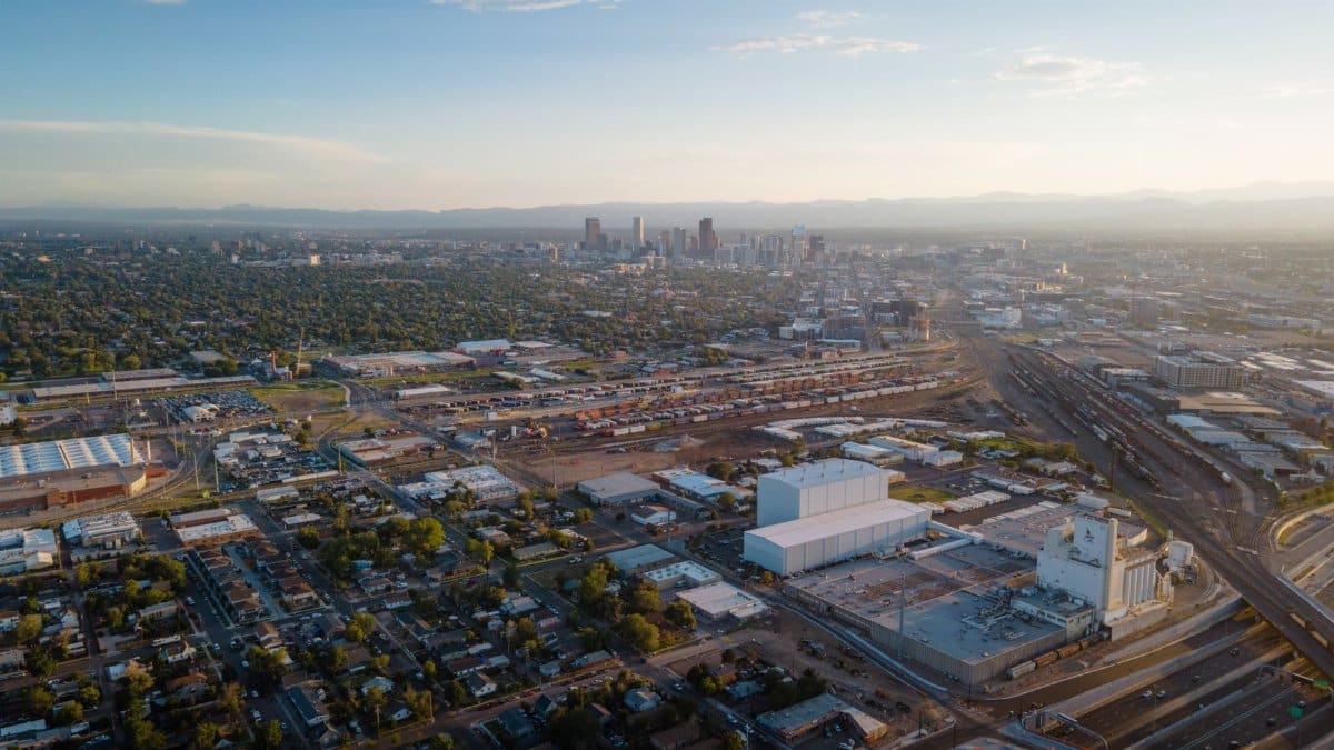 Stunning aerial view of Denver cityscape with urban sprawl and distant skyline at dusk.