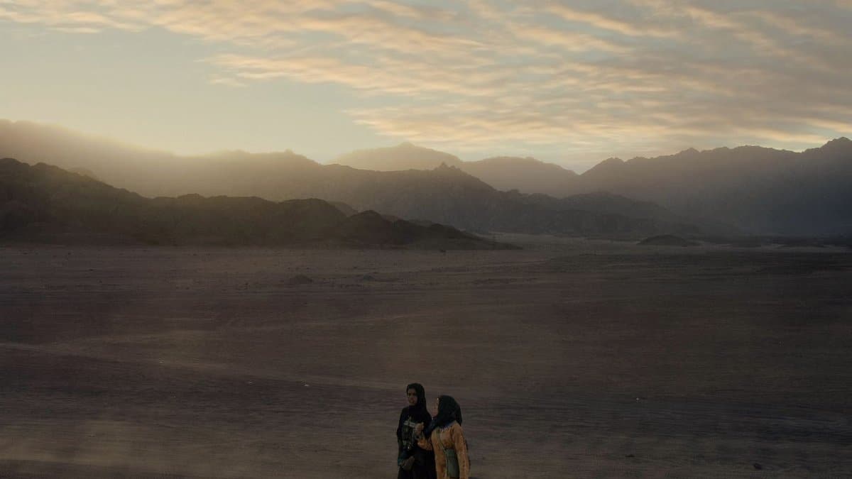 Two women walking at sunset in the majestic Egyptian desert near Sharm El-Sheikh.