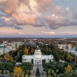 Stunning aerial view of the California State Capitol during a beautiful sunset with vibrant clouds.