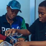 Two students assembling a robot in a hands-on STEM workshop in Accra, Ghana.