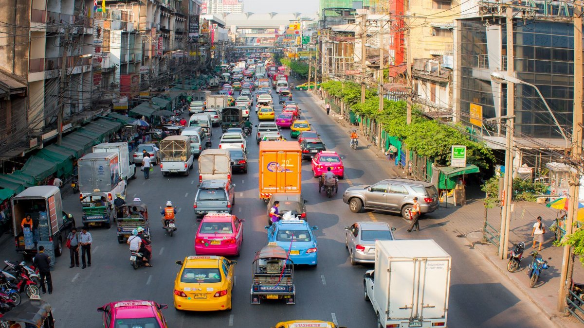 Vibrant city street bustling with traffic and pedestrians, showcasing urban life.