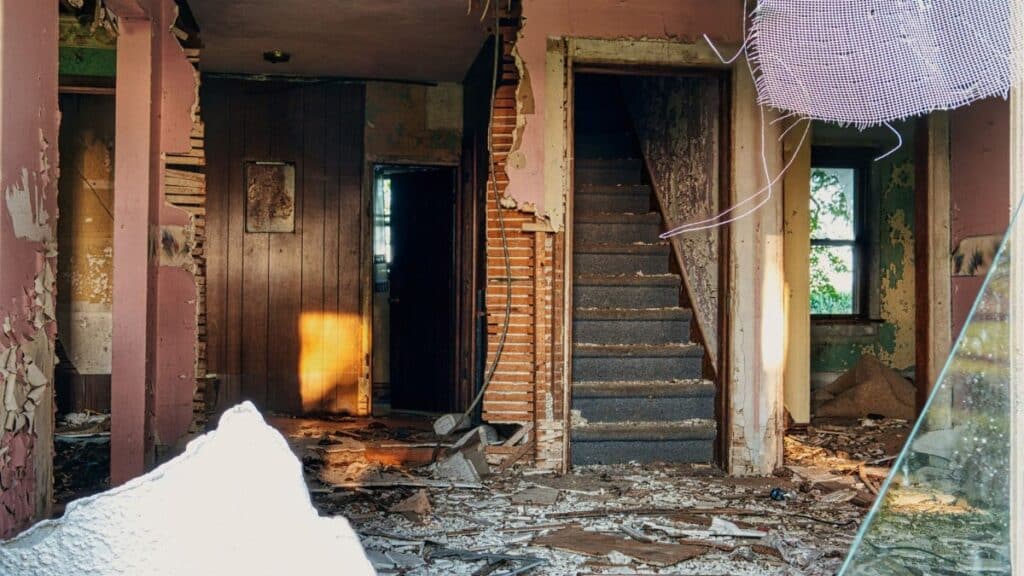 Explore an eerie abandoned interior featuring a crumbling staircase and deteriorating structures in MN, USA.