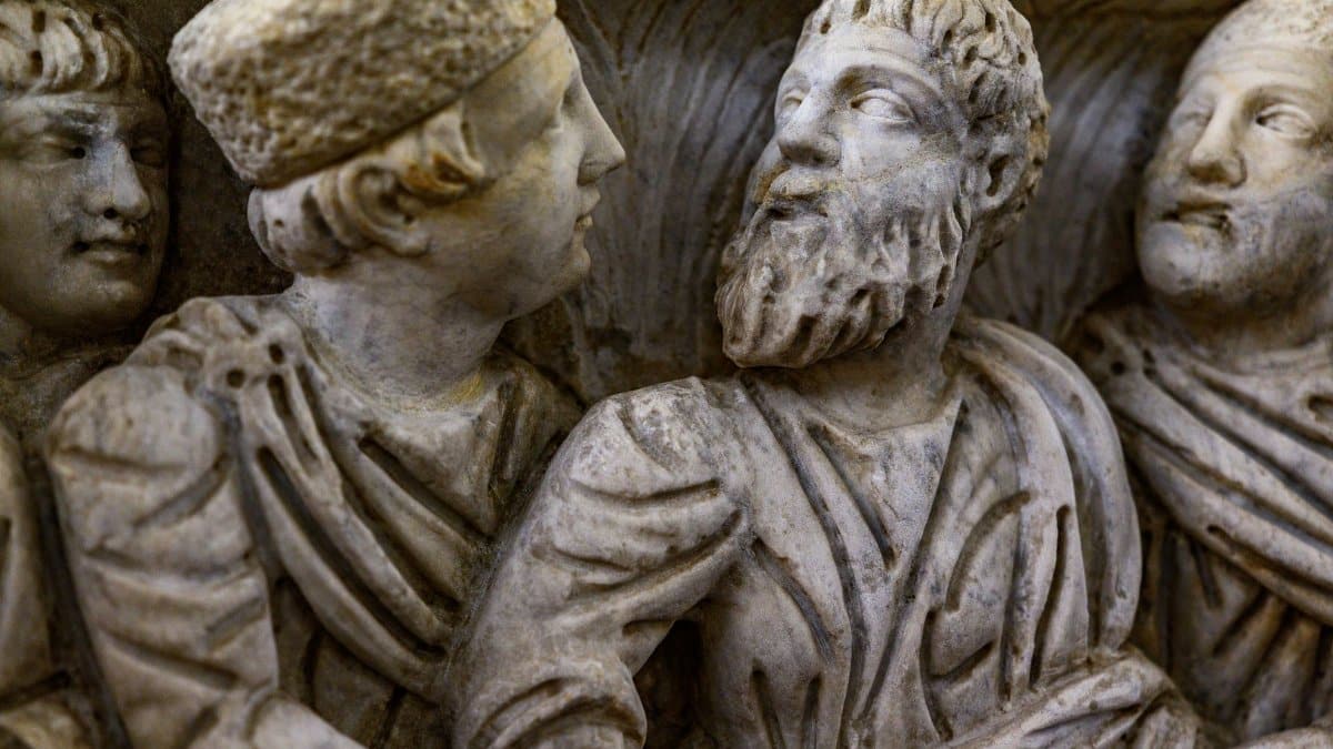 Close-up view of an intricately carved marble relief sculpture featuring bearded figures in the Vatican Museum.