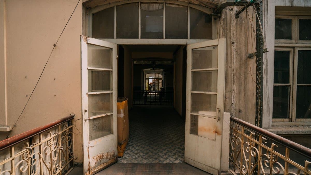 Vintage building exterior with open doors leading to a nostalgic hallway.