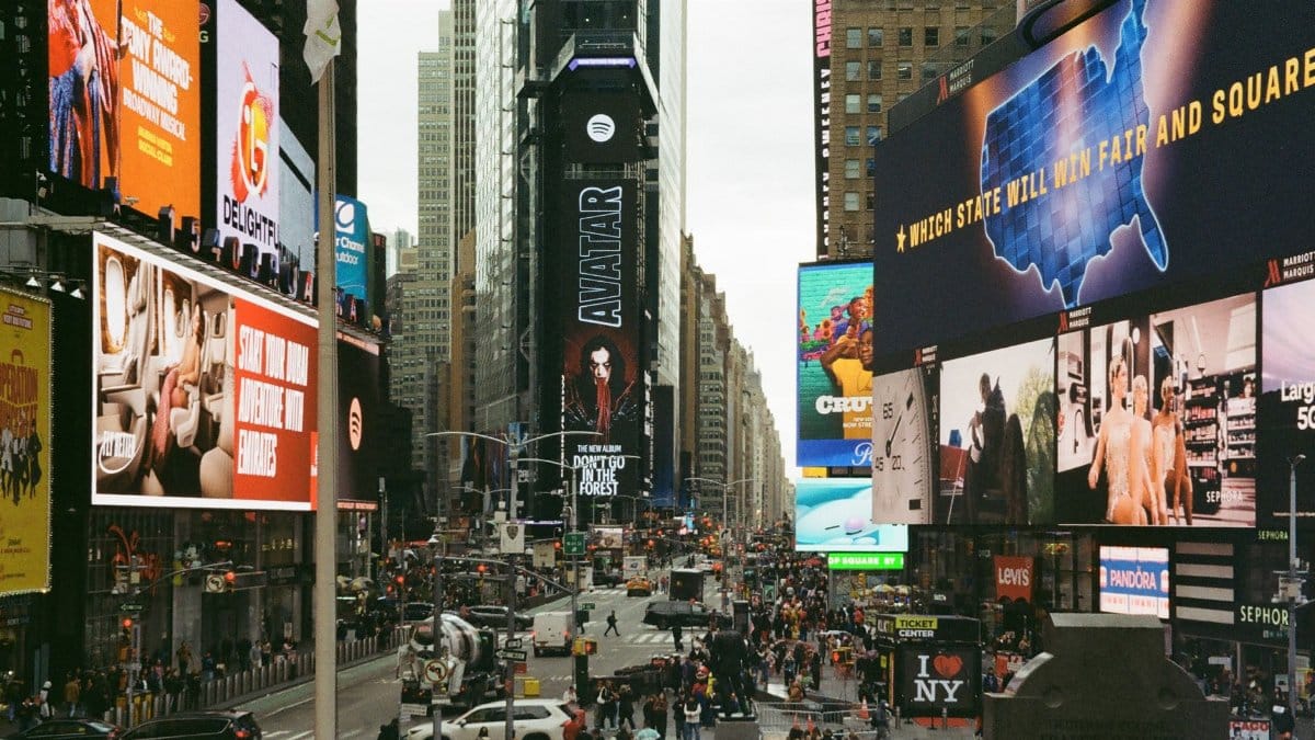 Times Square in New York City bustling with life, showcasing colorful billboards and busy crowds.