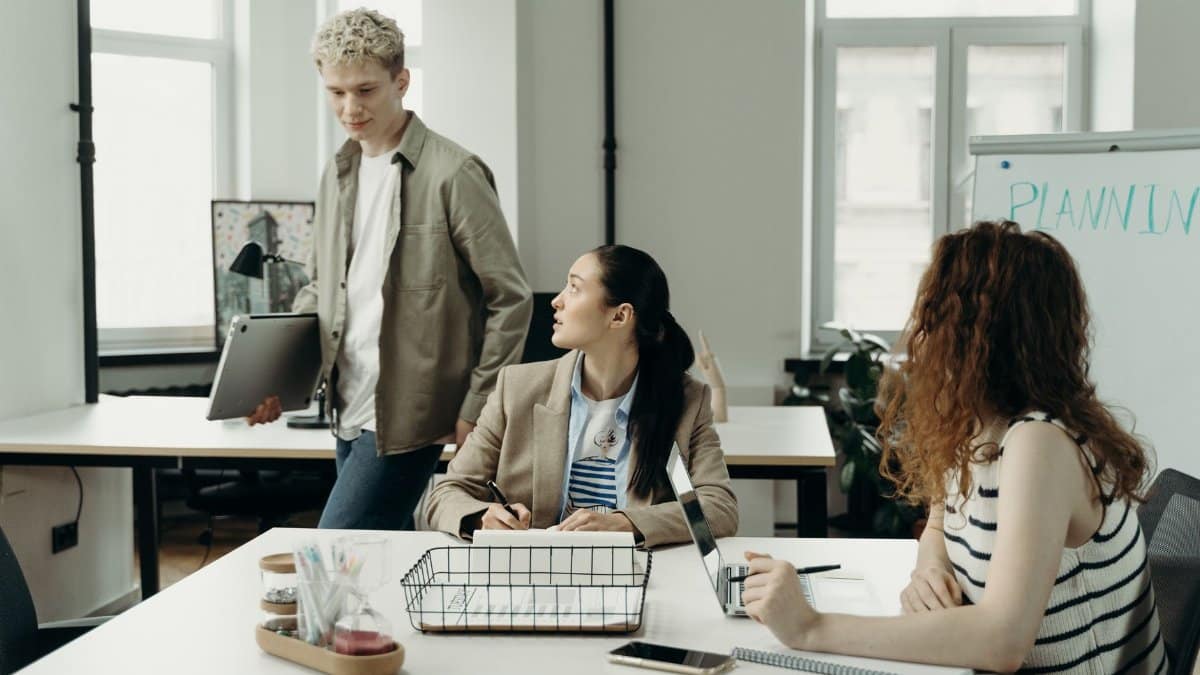 A diverse team of professionals collaborating in a modern office environment, engaged in planning and project development.